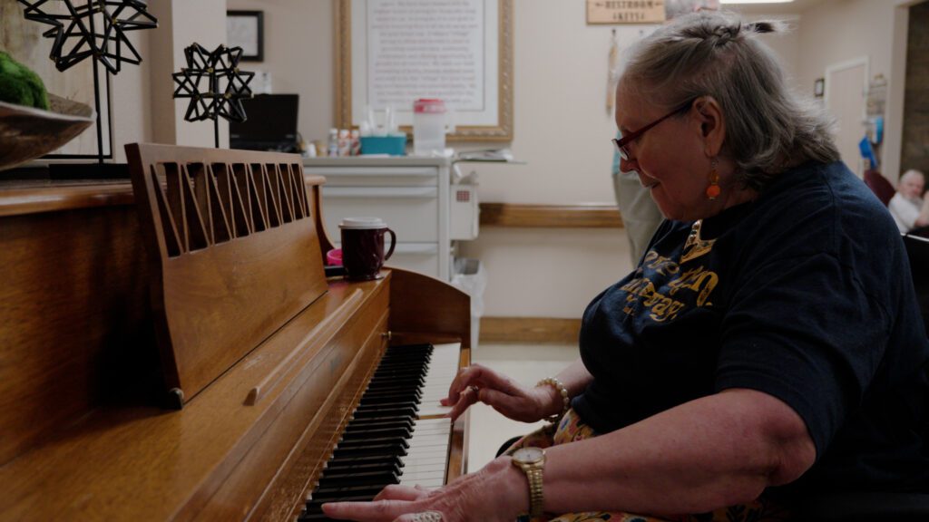 a woman plays the piano at a respite care facility